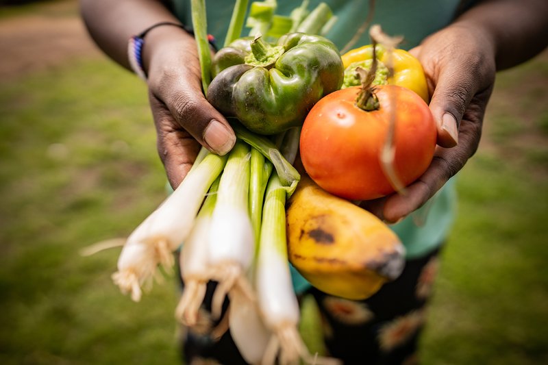 Gwenna Hunter holds local produce during a vegan food aid program supported by Vegan Outreach. USA, 2021. Nikki Ritcher / #unboundproject / We Animals Media